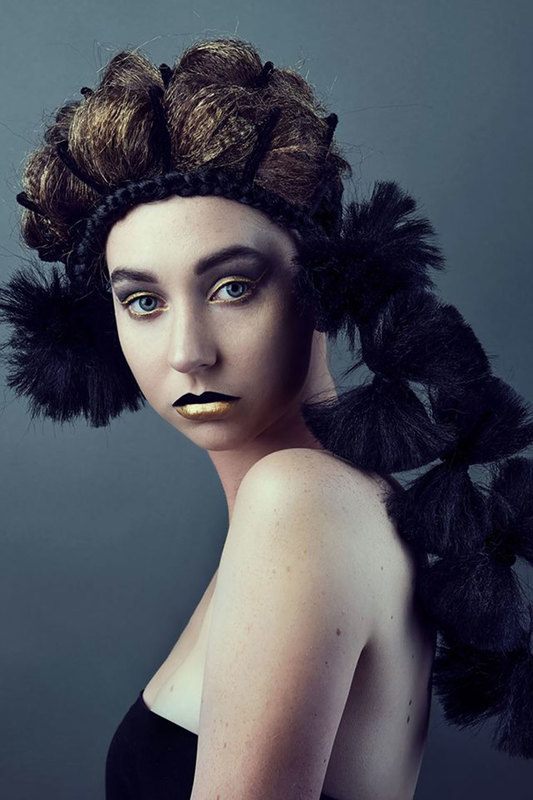 A woman with headdress and gold hair, posing