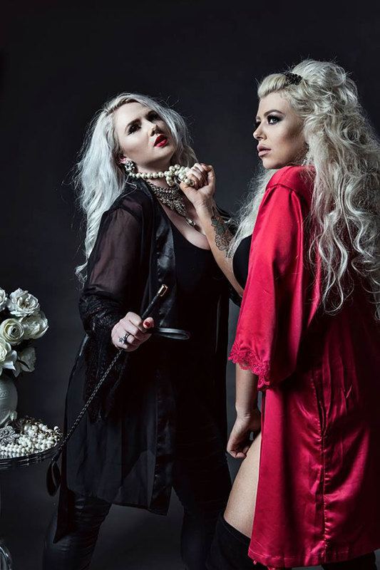 two women, one is holding the other woman in her necklace