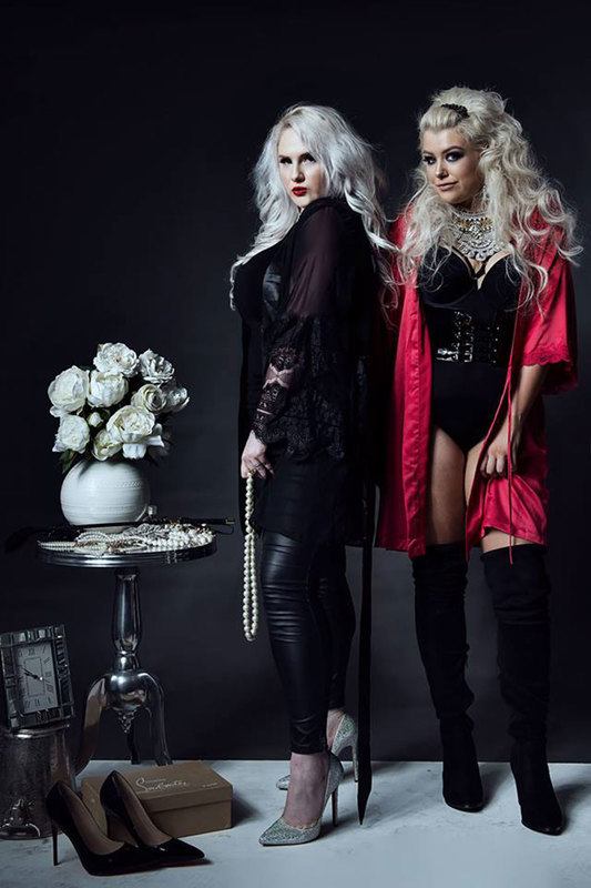 Two women, standing and posing