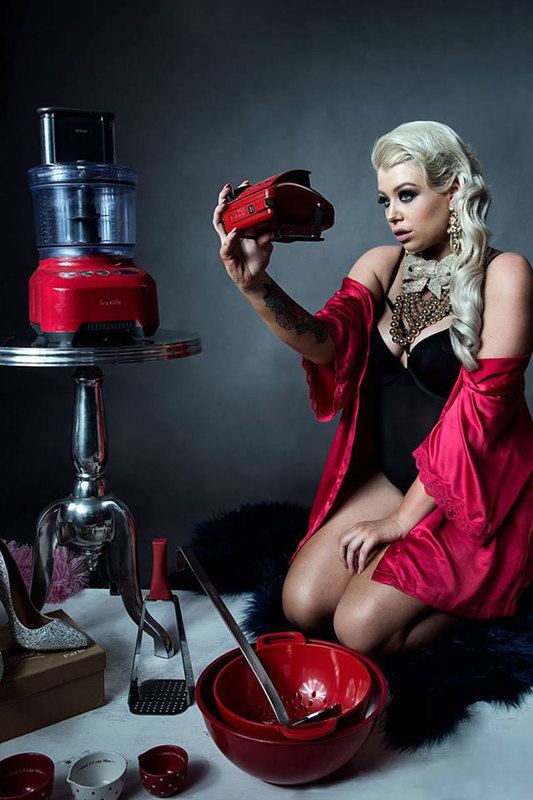 A woman in red robe, seated while posing