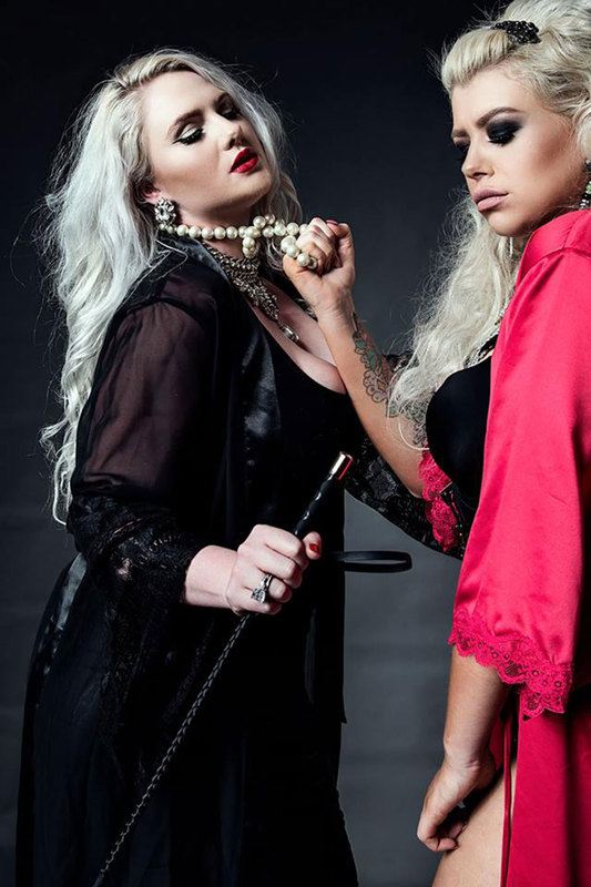two women, one is holding the other woman in her necklace