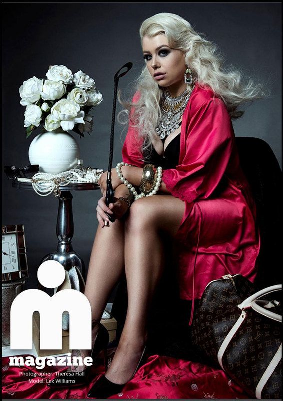 A woman on a magazine shot, in red robe, holding a stick while posing