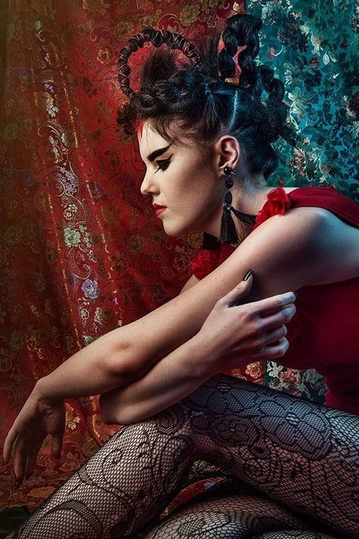 A woman with Ancient Japanese inspired make-up, posing while seated