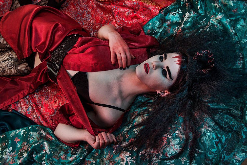 A woman with Ancient Japanese inspired make-up, laying down