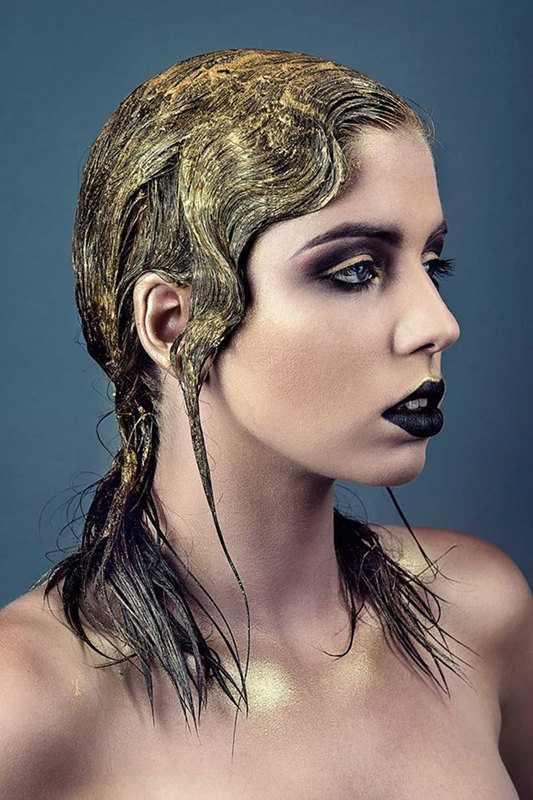 A woman with gold on her hair, close-up
