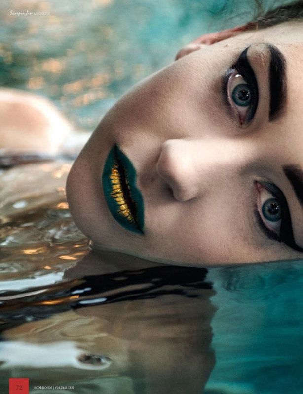 A close up shot of a woman with gold streaks in her lips dipped in water