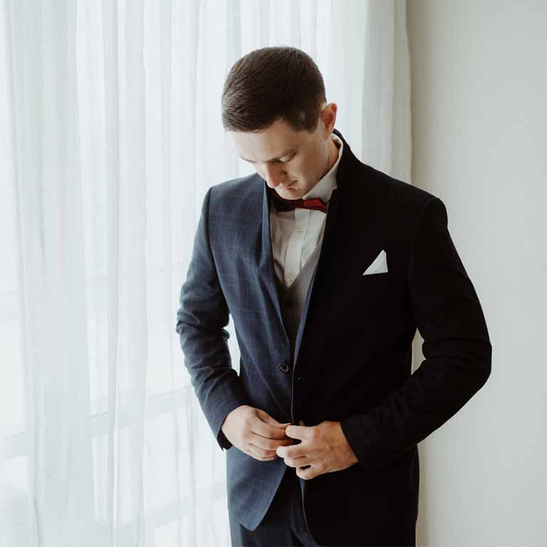 A man on a formal dress preparing for a wedding