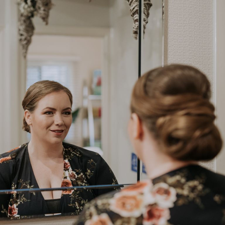 A woman facing a mirror