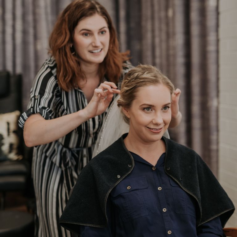 A woman styling another woman's head