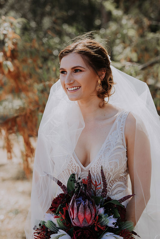 A woman in white gown holding a bouquet of flowers