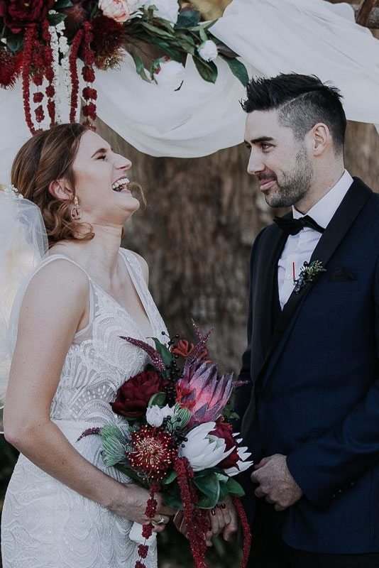 A woman laughing while a man is staring at her