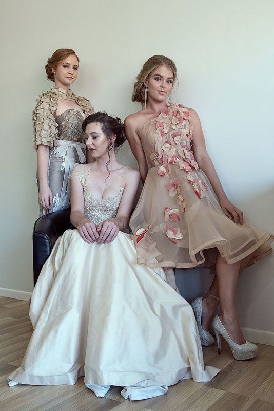 Three women. One is standing, one is leaning on the couch, one woman is sitting