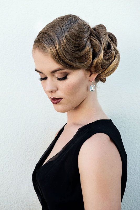 A woman with black dress looking downwards, close-up shot