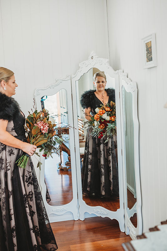 A woman holding a bouquet of flowers, facing a mirror