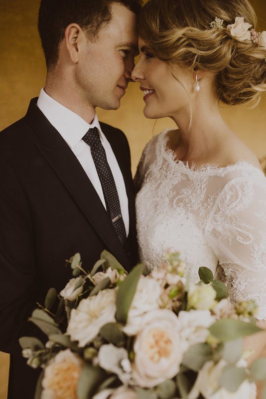 A man and a woman, close to each other, posing