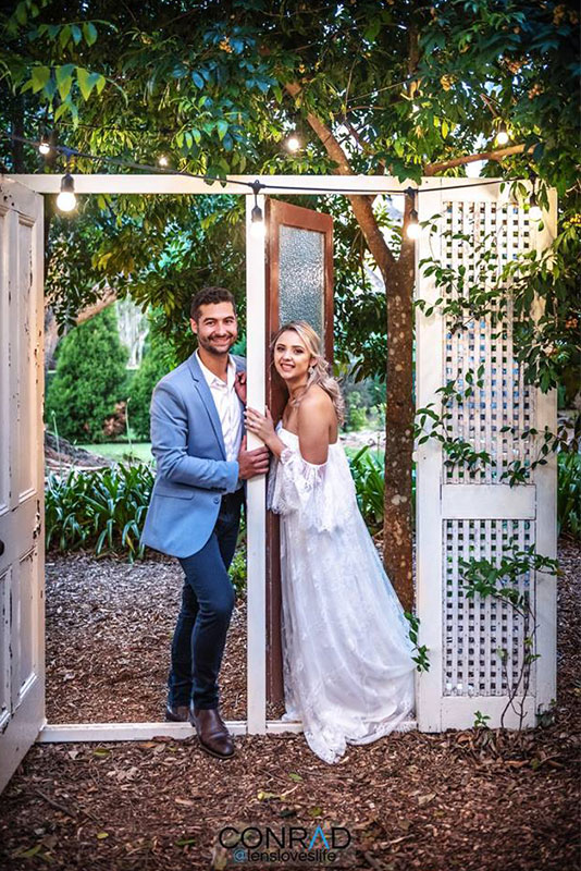 A man and a woman posing on a garden